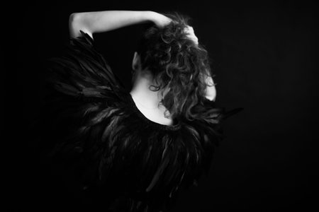 girl in feathers, beautiful cape made of raven feathers on a slender female body, black and white...
