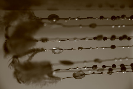 beads and stones on a string, a homemade dream catcher made of feathersの写真素材