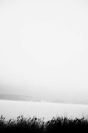 black and white noisy and fuzzy winter landscape shot on film, wild and deserted winter beach and embankment, the concept of minimalism and silenceの写真素材