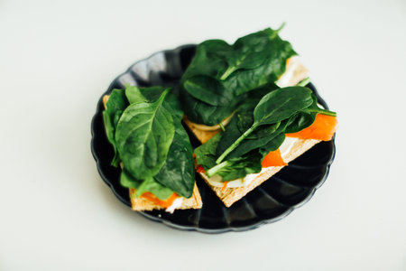 Sandwich with salmon, tender cheese and spinach on a blue plate. Healthy diet sandwich of fish and breadの写真素材