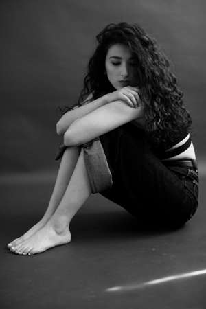 A sensual black and white portrait of a brunette girl with curly hair.の写真素材