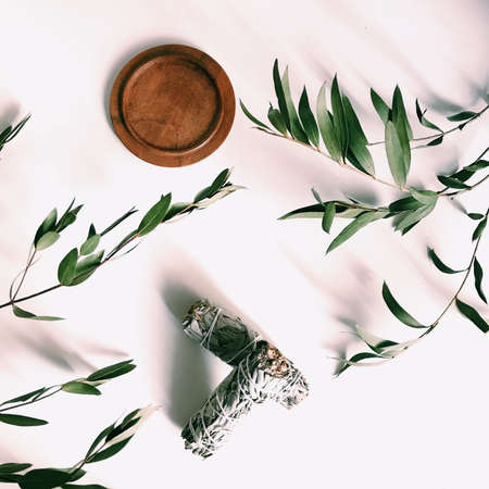 the layout of incense on a neutral background. palo santo and white sage, eucalyptus leaves and wooden standの写真素材
