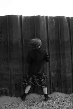 fashion portrait of a girl in a black long jacket in an authentic locationの写真素材