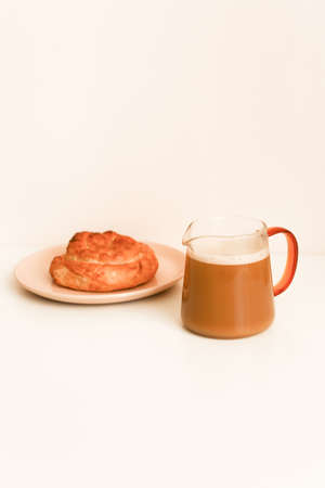 Snail bun and cappuccino, neutral coffee shop backgroundの写真素材