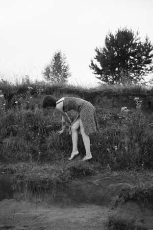 a girl walks in a field, a summer black-and-white photo, a walk in nature in a long dressの写真素材