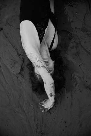 a dancer moves freely on the beach, art shooting of a dancer on black and white film. A woman in a black bodysuit on the beachの写真素材