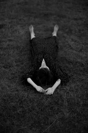 a girl walks in a field, a summer black-and-white photo, a walk in nature in a long dressの写真素材