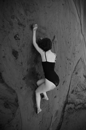 a dancer moves freely on the beach, art shooting of a dancer on black and white film. A woman in a black bodysuit on the beachの写真素材