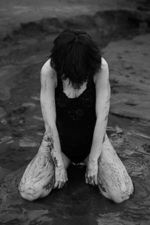 a dancer moves freely on the beach, art shooting of a dancer on black and white film. A woman in a black bodysuit on the beachの写真素材