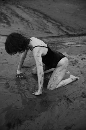 a dancer moves freely on the beach, art shooting of a dancer on black and white film. A woman in a black bodysuit on the beachの写真素材