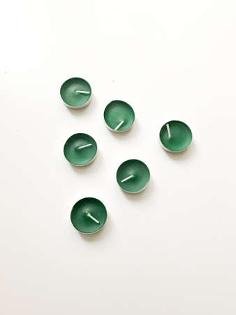 Set of green small candles on white background. Flat lay, top view. Aesthetic minimalist concept.の写真素材