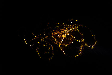 Abstract orange and gold dark background with glowing turquoise particles.