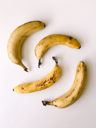 Very ripe bananas on a white background, a pattern of bananas with brown spotsの写真素材