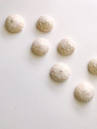 A set of curd round cookies on a white background, white glaze and coconut chips on a confectionery...