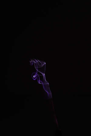 Pink and scarlet patterns of smoke from cigarettes and hookah, fumigation of a magical spaceの写真素材