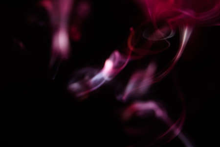 Pink and scarlet patterns of smoke from cigarettes and hookah, fumigation of a magical spaceの写真素材
