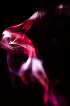 Pink and scarlet patterns of smoke from cigarettes and hookah, fumigation of a magical spaceの写真素材
