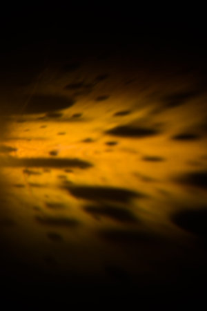 abstract orange-yellow background, glare and blur, surface ripples, radiance and sparksの写真素材