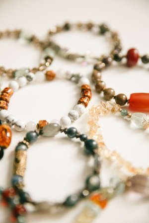 Bracelet made of natural stones and minerals, macro photography of jewelry on a light background, soft focus backgroundの写真素材