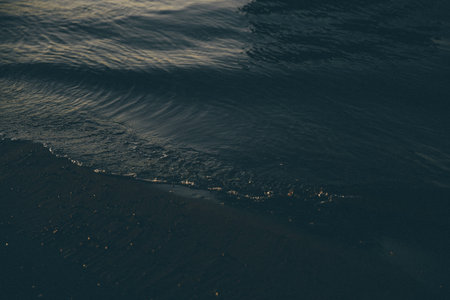 Sea waves on the black sand of the beach. Natural background.の写真素材