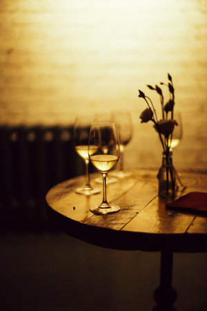 Glasses of white wine on a wooden table in a restaurant.