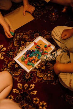 Children playing with colorful clay on the carpet.の写真素材