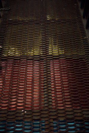 A vertical shot of a row of red and yellow tiles on a roofの写真素材