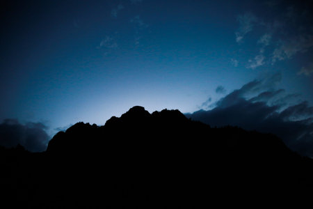 Silhouette of a mountain peak in the evening with dark clouds