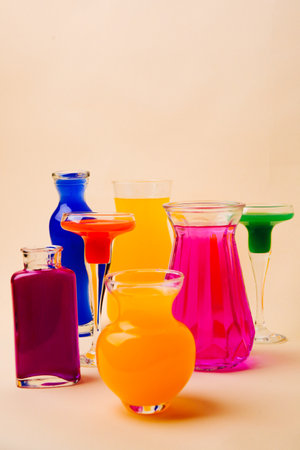 Glass vases and glasses with multicolored water, art background for drinksの写真素材