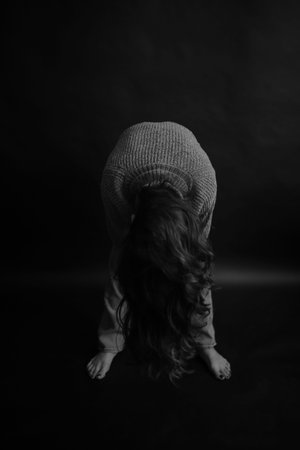 Portrait of a beautiful girl in a sweater on a black background