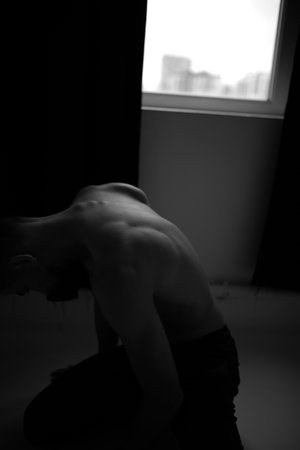 Young woman in a dark room. Black and white photo.の写真素材