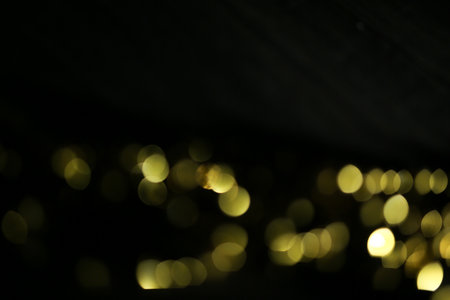 Gold bokeh on black background. Christmas and New Year concept.の写真素材