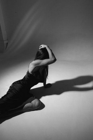 Black and white photo of a young beautiful woman in a black dressの写真素材