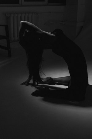 silhouette of a girl in a black dress in the darkの写真素材