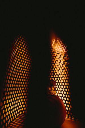 A closeup shot of a bottle of perfume in a dark roomの写真素材