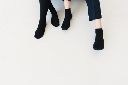 Women's legs in black socks on a white background. Top view.の写真素材