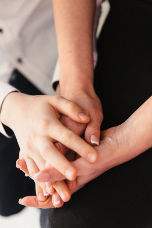Close-up of hands of business people holding each other on white backgroundの写真素材