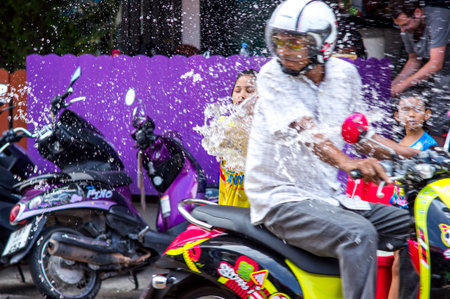 Patong, Phuket, Thailand - 04/13/2014. Songkran Festival. Thai girl drenches a bike with people...