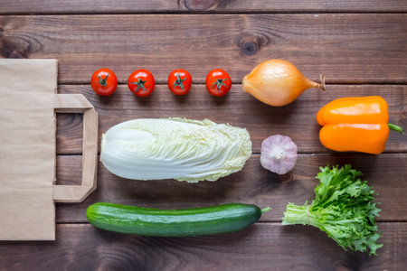 Top view vegetables on a paper bag on a wooden backgroundの写真素材