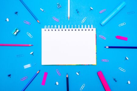 Back to School concept. Top view school supplies and stationery on a student desk on blue background. Flat lay and copy spaceの写真素材