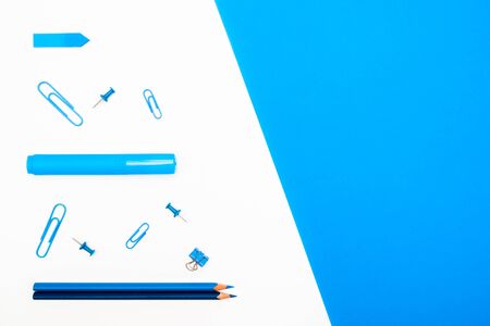 Back to School concept. Top view school supplies and stationery on a student desk on white and blue background. Flat lay and copy spaceの写真素材