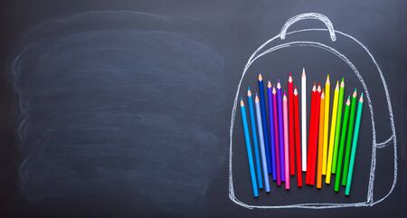 Back to school concept. Top view of a backpack with colored pencils. Flat lay and copy spaceの写真素材