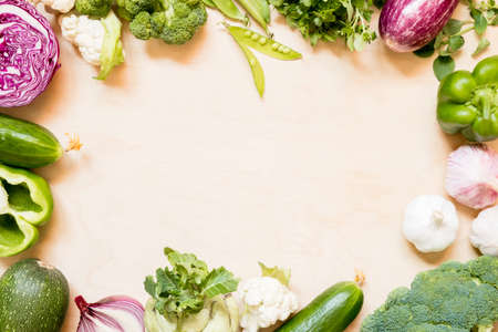 Top view set raw of green, red and purple vegetables spread on wooden background. Copy spaceの写真素材
