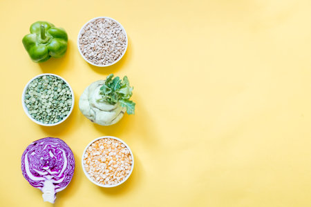 Vegetarian food concept. Top view set raw of green, red vegetables and protein on yellow background....