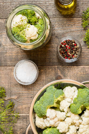 Top view jar with canned cauliflower and seasonings on wooden kitchen table. Food preservation and conservation conceptの写真素材