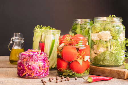 Jars with canned vegetables on wooden kitchen table. Food preservation and conservation conceptの写真素材