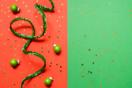 New Year or Christmas composition 2021. Top view xmas decorative red and green paper background with tinsel and Christmas decorations wiht copy space. Mockup greeting card. Flat layの写真素材
