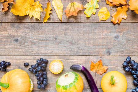 Autumn background with yellow leaves and vegetables. Frame of fall harvest on aged wood with copy space. top view and flat layの写真素材