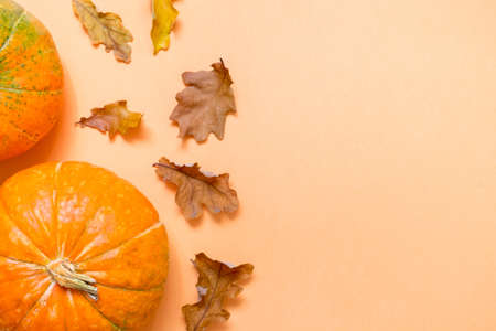 Autumn background with oak yellow leaves and pumpkins. Frame of fall harvest on aged wood with copy space. top view and flat layの写真素材