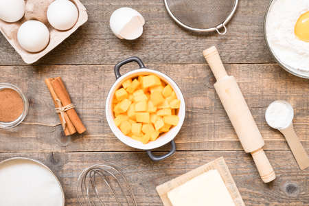 Top view raw ingredients for cooking pumpkin pie on wooden background. Bakery backgroundの写真素材
